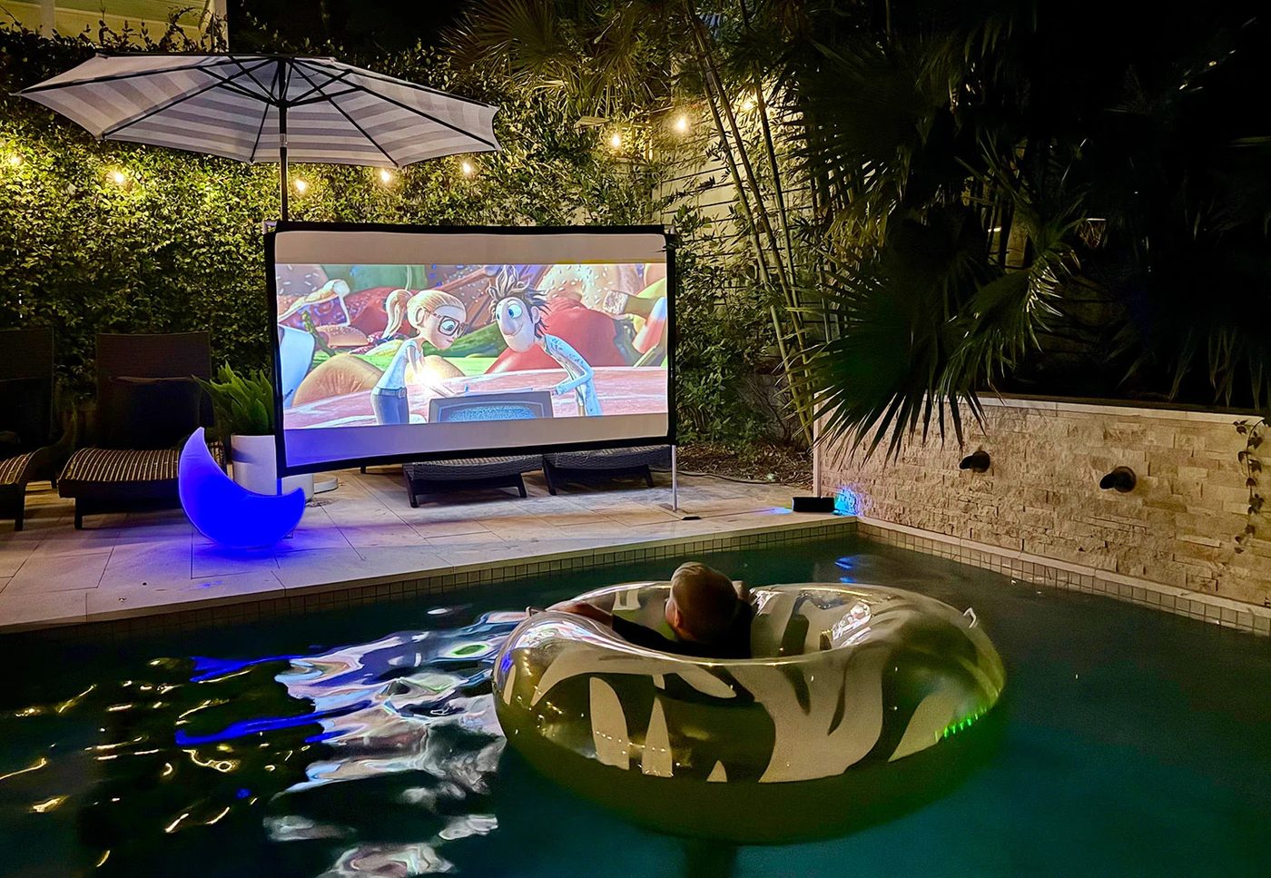 Boy Watching Cloudy With A Chance of Meatballs 2 From Pool Float on Outdoor Movie Night
