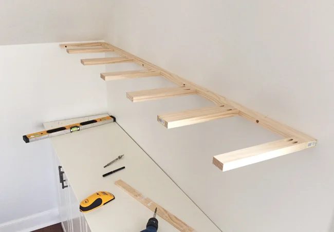 Brace piece of Hands-on thin wood floating shelves hung on a wall using 1x3 and 1x2 pine boards