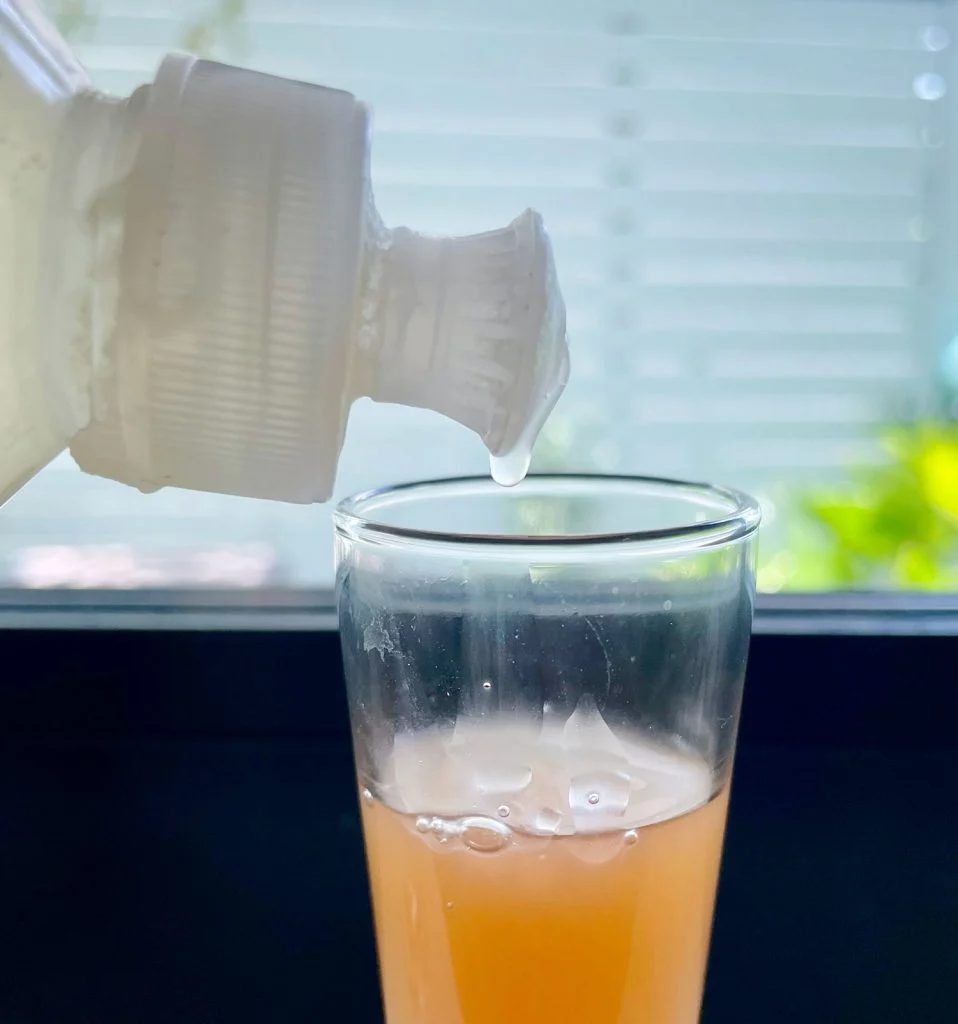Dripping Dish Soap Into Apple Cider Vinegar For Hands-on Fruit Fly Trap