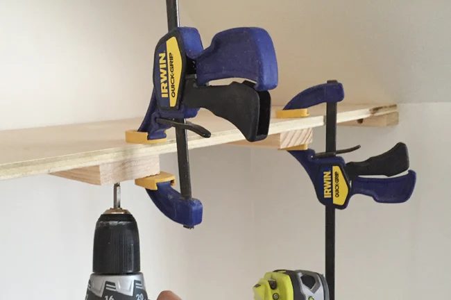 Screwing on a top plywood piece for thin floating shelves using Irwin Swift Grip clamps to hold the in place