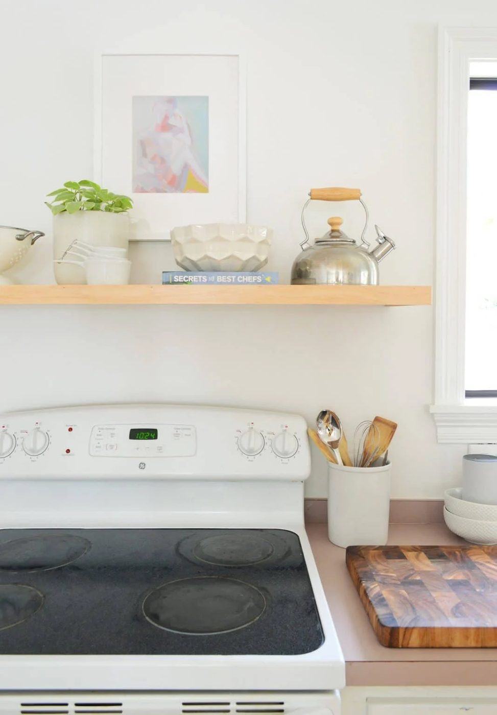 Plain Floating Shelf Constructed Over Old White Stove In Minimal Kitchen