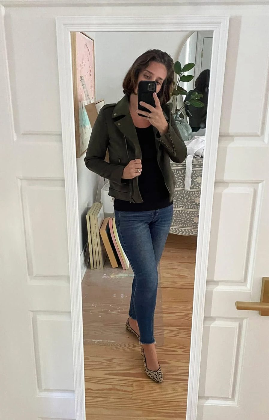 Sherry selfie in mirror at home with black tank top with green jacket with leopard print flats