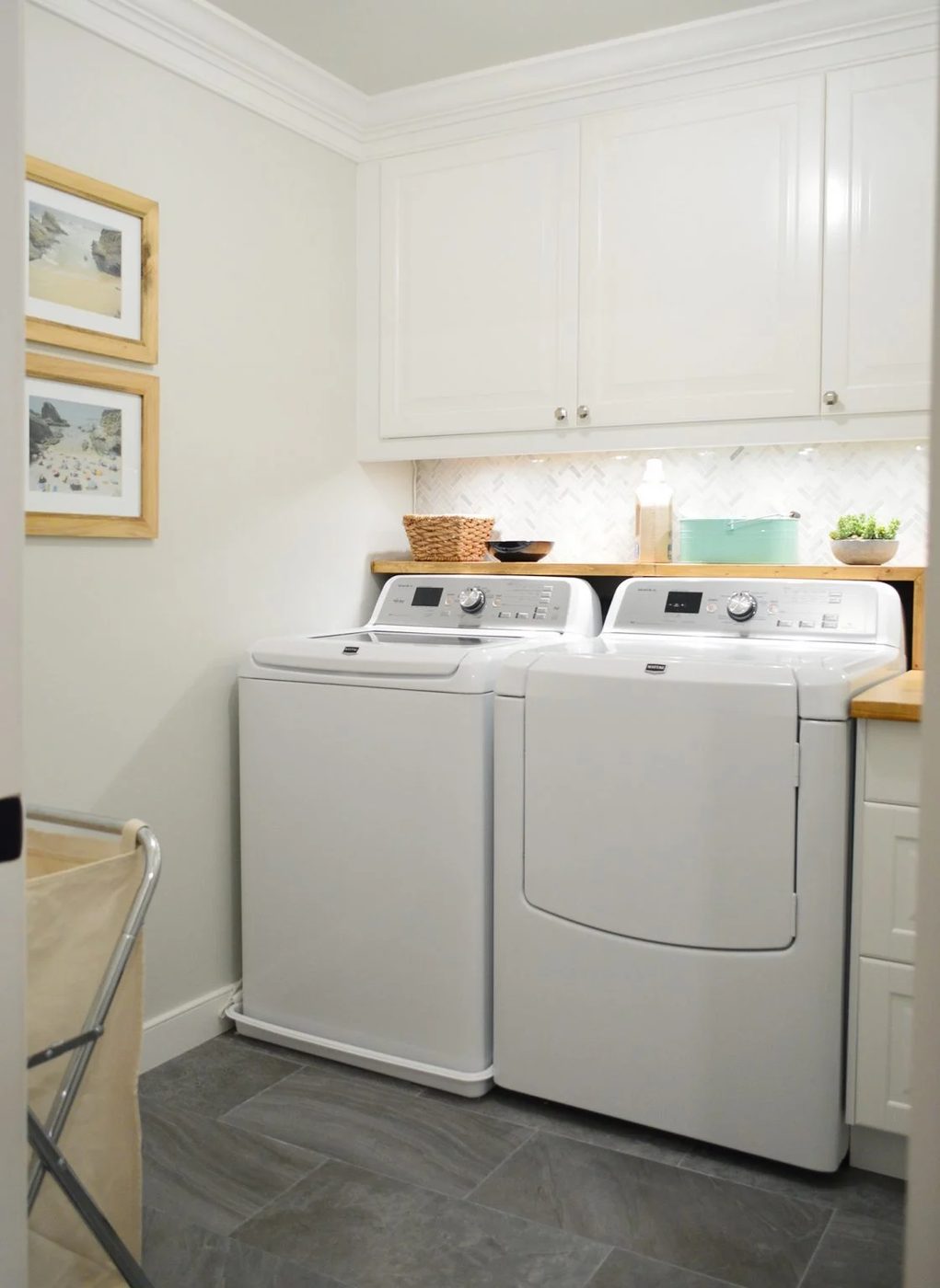 Tiled laundry room with wood butcher block Hands-on shelf over washer and dryer