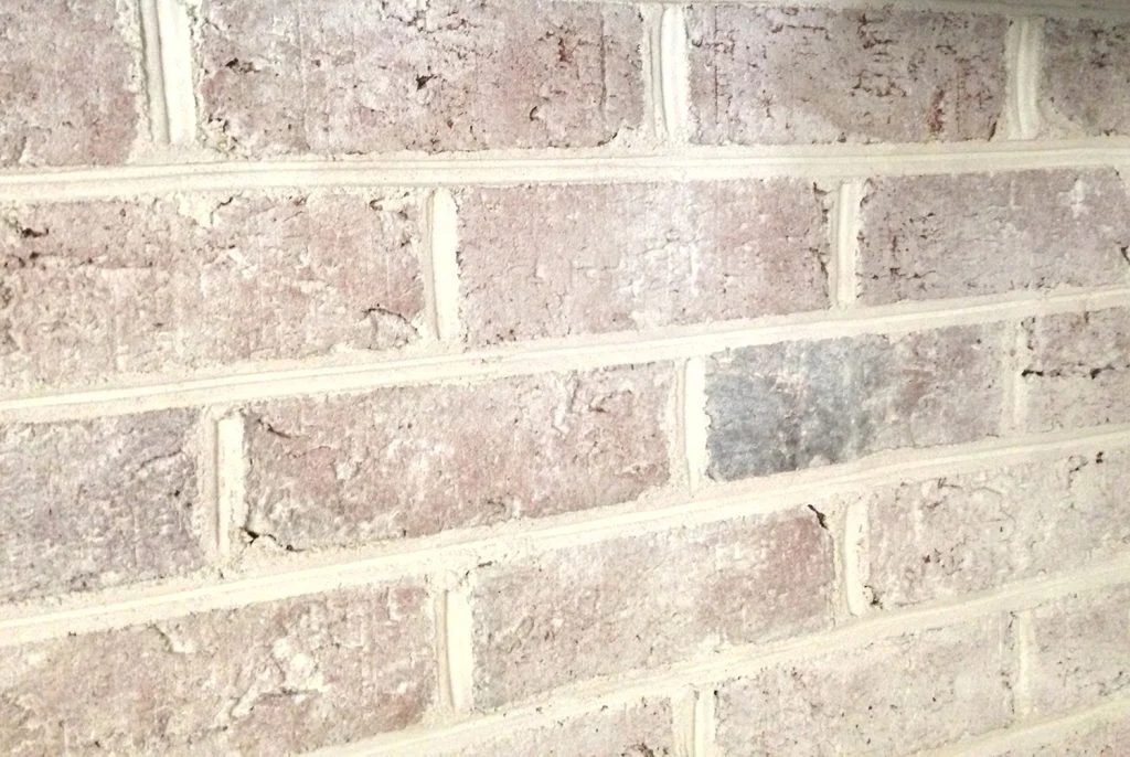 close up detail of brick wall fireplace with a Hands-on whitewash treatment applied