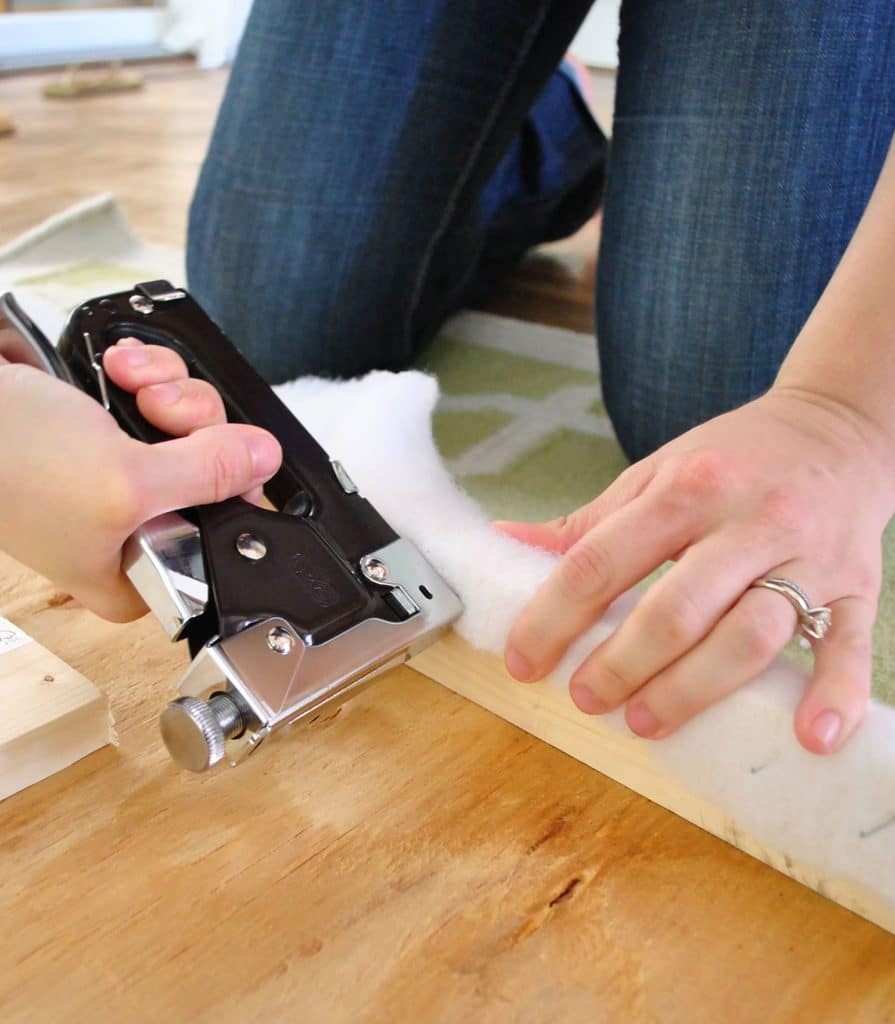 Using staple gun to attach batting to back of Hands-on upholstered fabric headboard