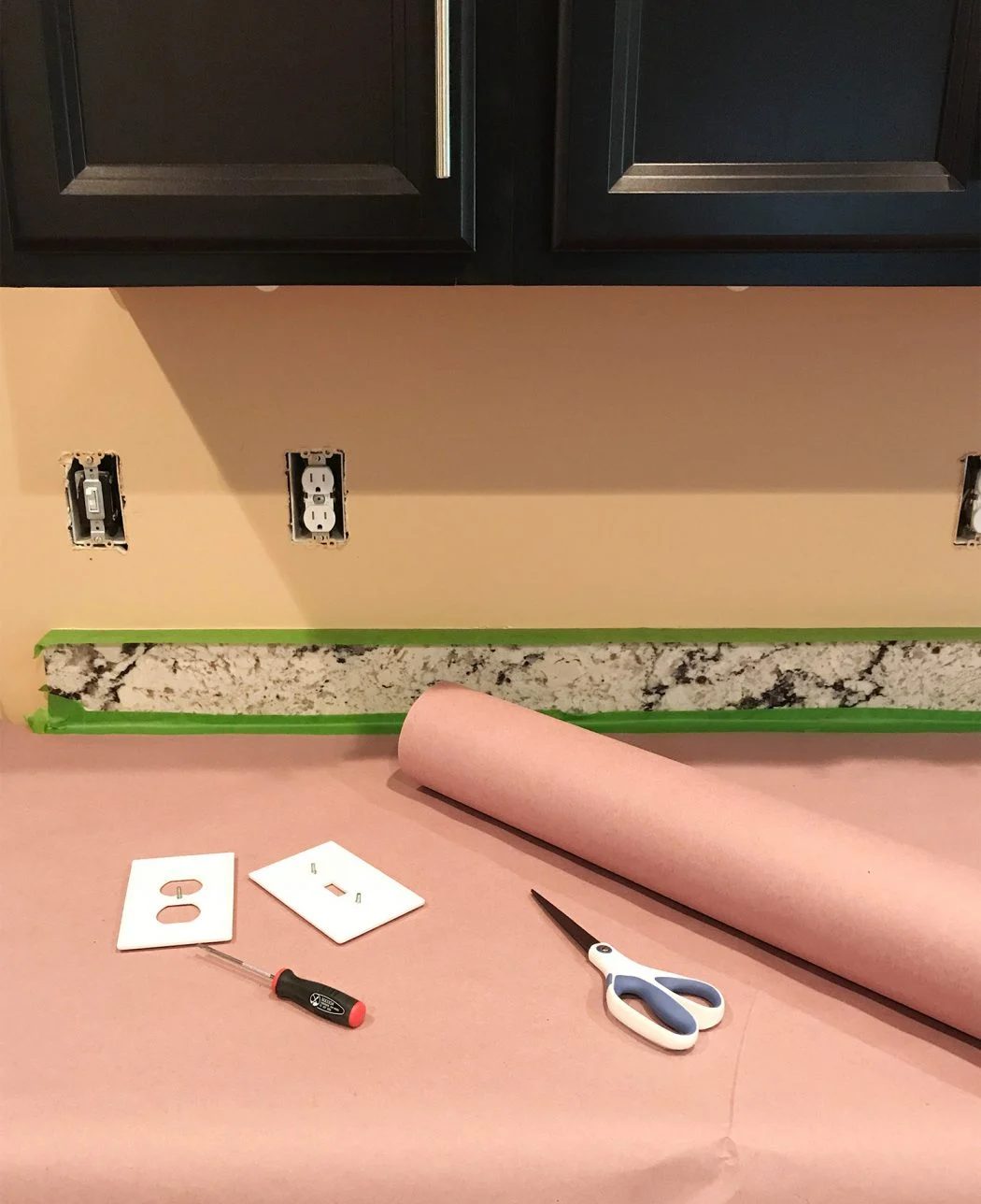 kitchen prepared for tiling with outlet covers took out and counters protected