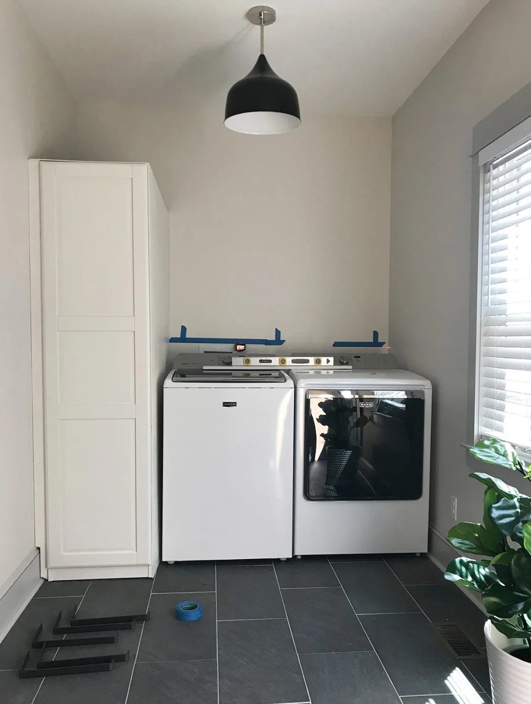 ikea pax wardrobe placed next to top loading washer and dryer in laundry room