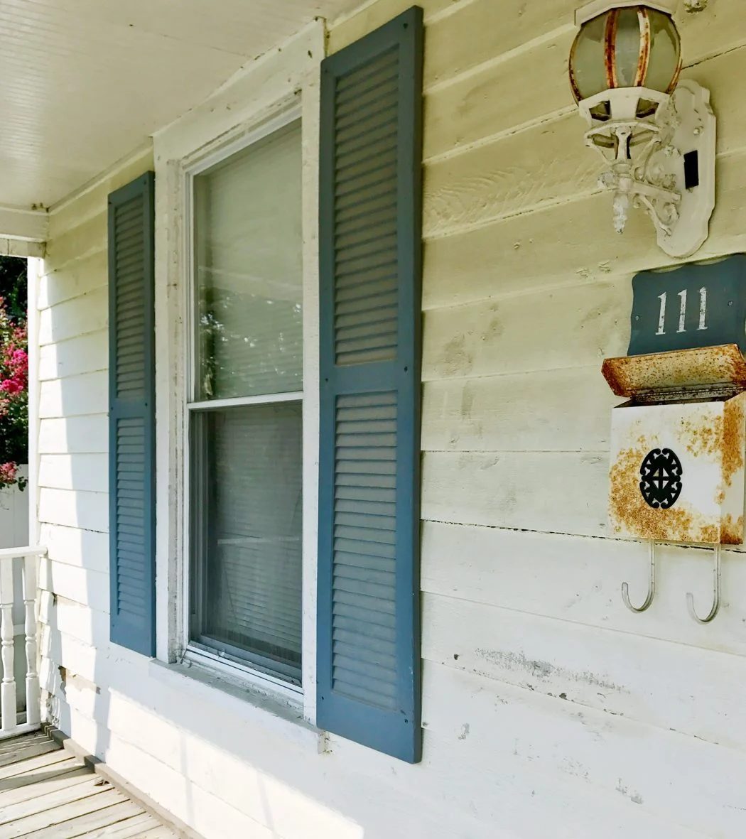 Before Detail of Font Porch With Dirty Siding And Blue Shutters