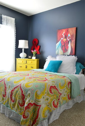 Lively Bedroom With Paisley Bedspread and Yellow Dresser