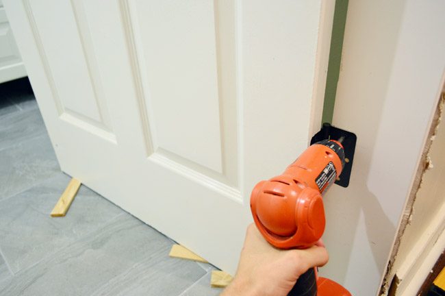 Hanging Door In Hands-on Jamb Using Screwdriver To Attach Door Hinges