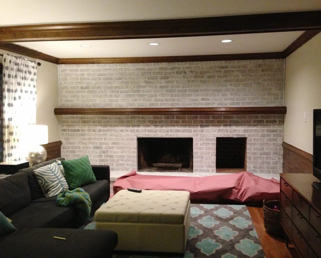 lightly whitewashed brick wall in living room with fireplace and mantle using leftover white paint