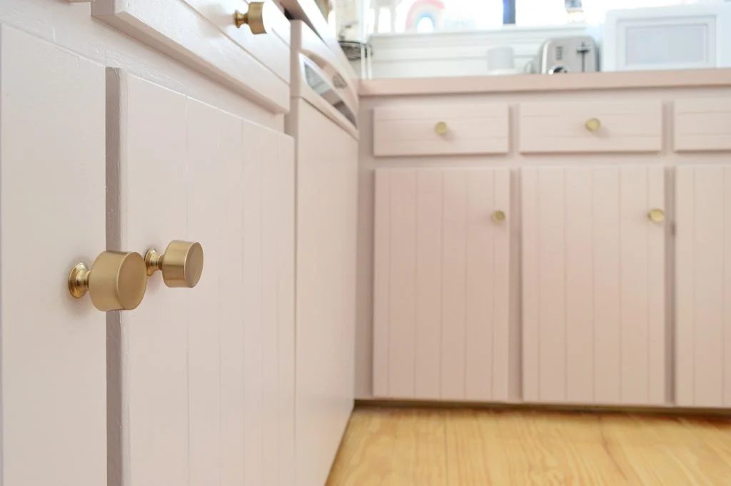 Close up after photo of mauve cabinets with brass gold hardware knobs