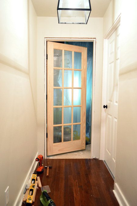 15 Pane Glass Unfinished Wood Door Hung At Entrance To Bonus Room In Hands-on Door Jamb