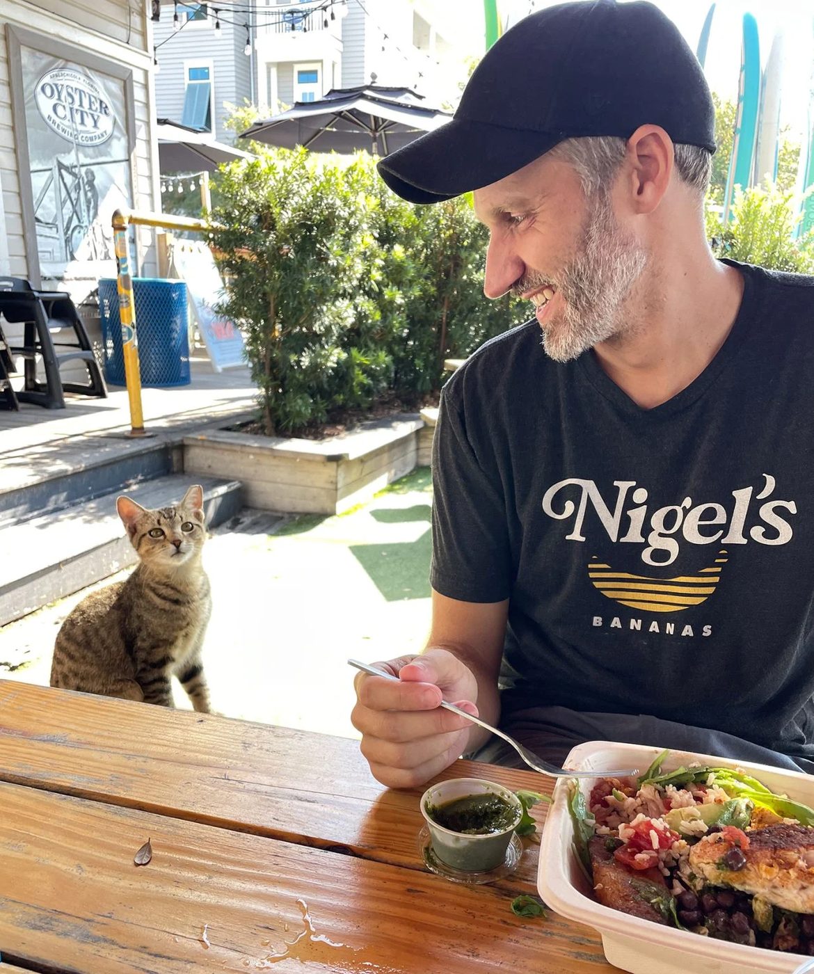John Eating Lunch Next To Boy Cat At Patio Restaurant