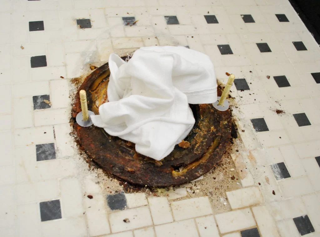 New Bolts On Toilet Flange With Rag In Sewer Hole