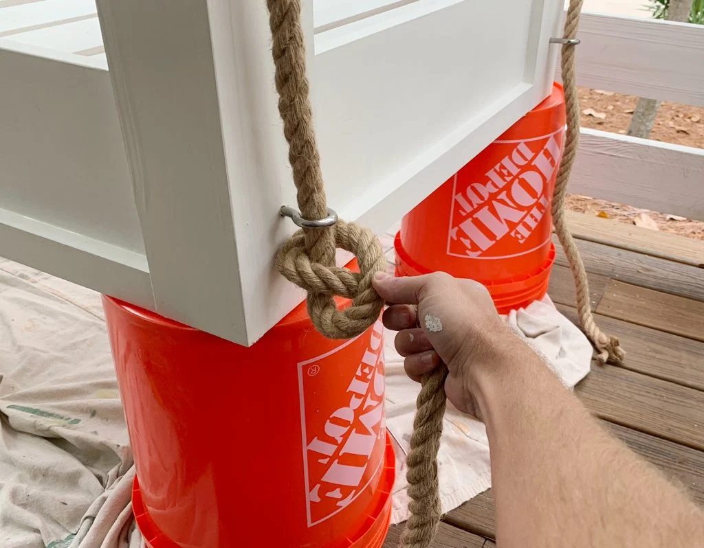 Typing pretzel knot on the bottom of hanging daybed under eyehook
