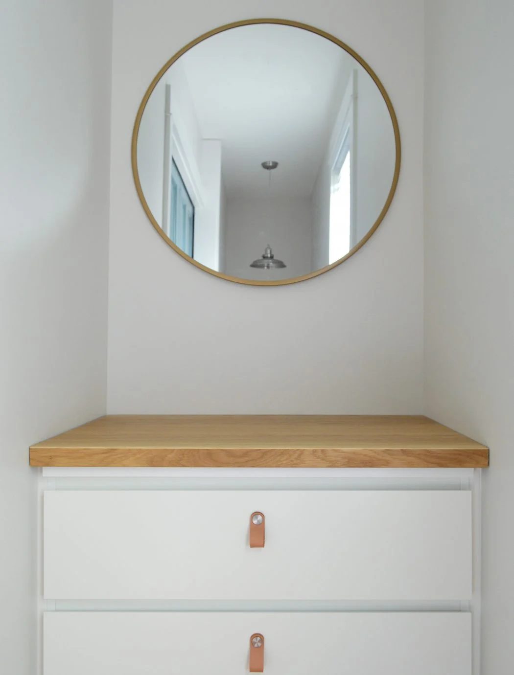 Ikea Malm Dresser With Butcher Block Counter And Leather Pulls Below Round Mirror