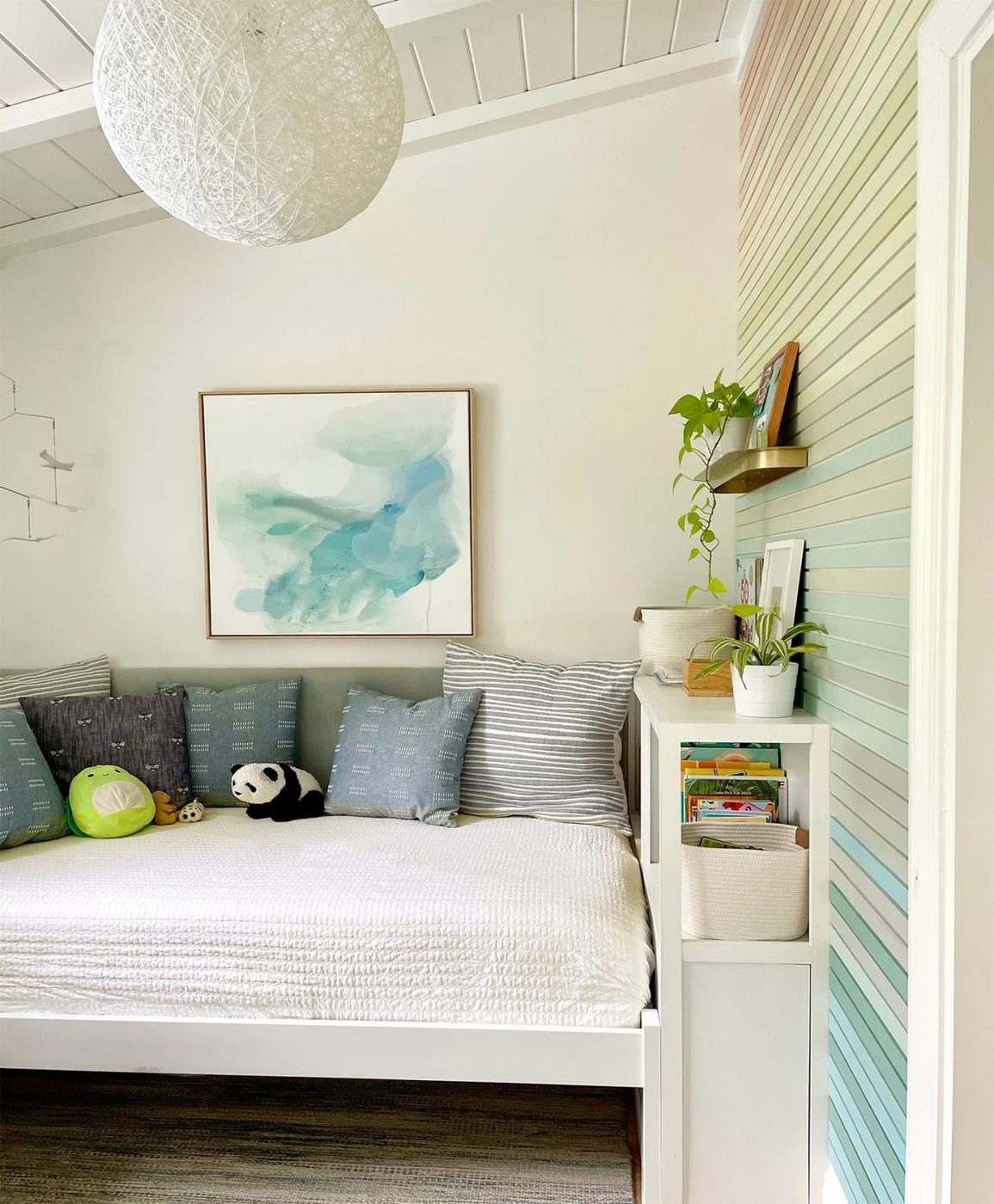 Built-In Bookcase Next To Bed With Upholstered Headboard In Kids Room With Vaulted Ceiling