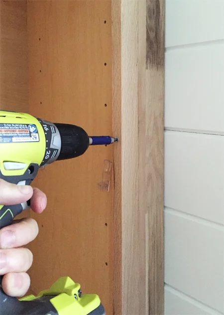 Screwing filler piece next to base cabinet for bookshelves