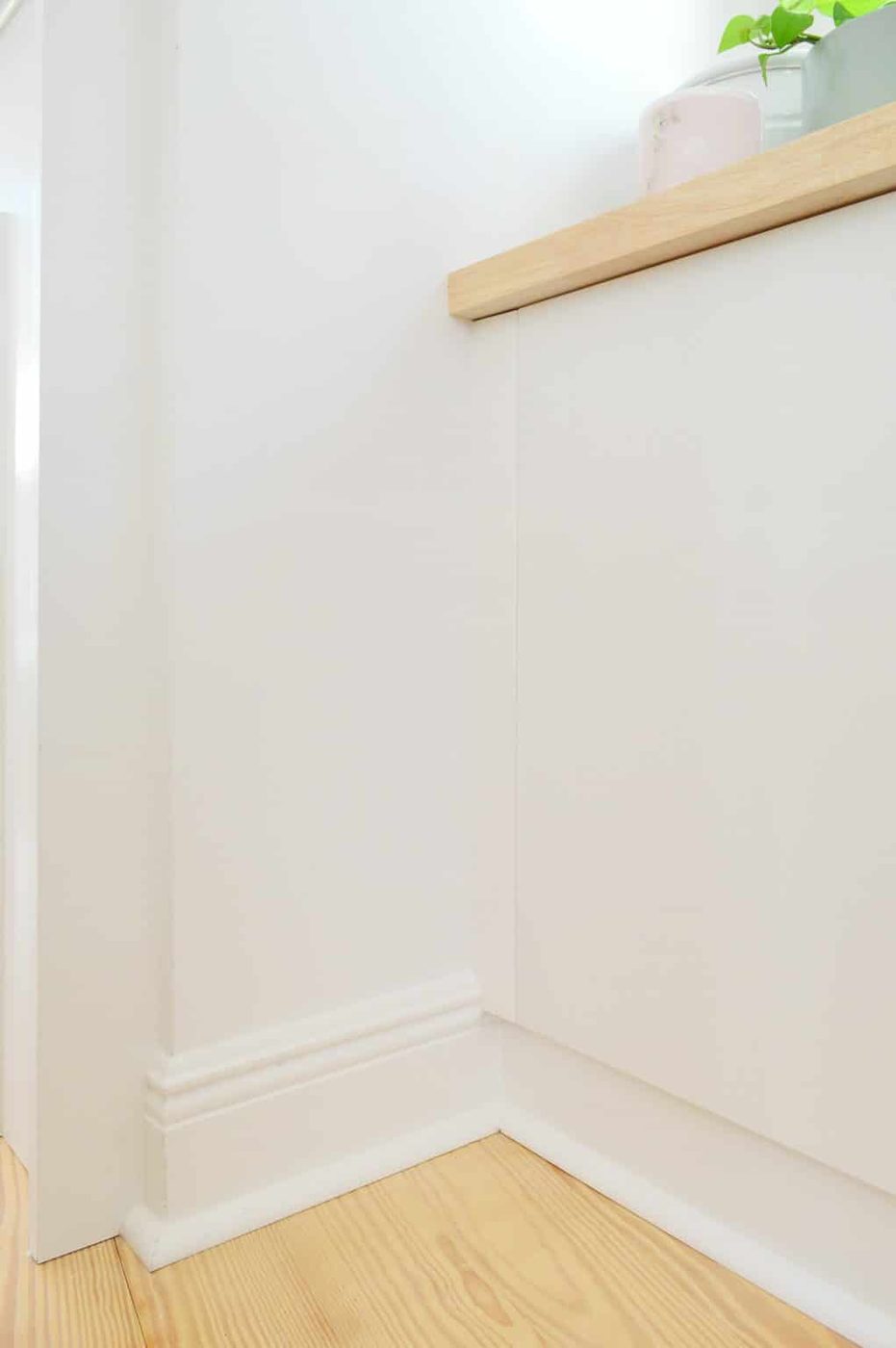 Close up detail of trim brought in to side of Ikea Besta cabinets to look flush with doors