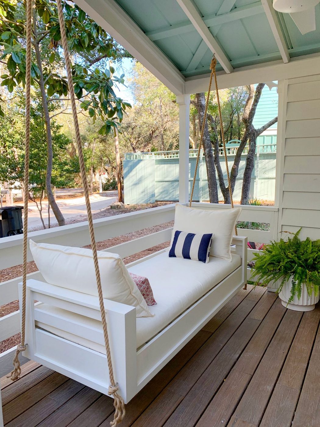 Angled View Of Wrapped up Outdoor Hanging Daybed With White Cushions