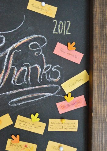 Hands-on leaning chalkboard with Thanksgiving message and gratitude notes held with magnets