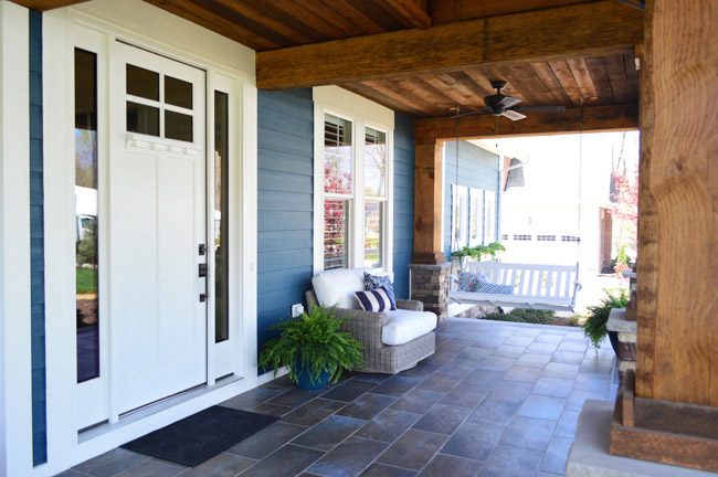 Wide Front Porch With Wood Beams And Columns And Hanging Porch Swing