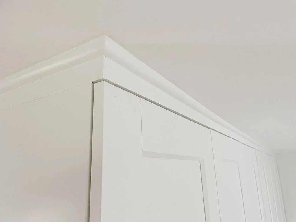 Wrapped up and painted quarter round molding that makes Ikea Pax Wardrobes look built in