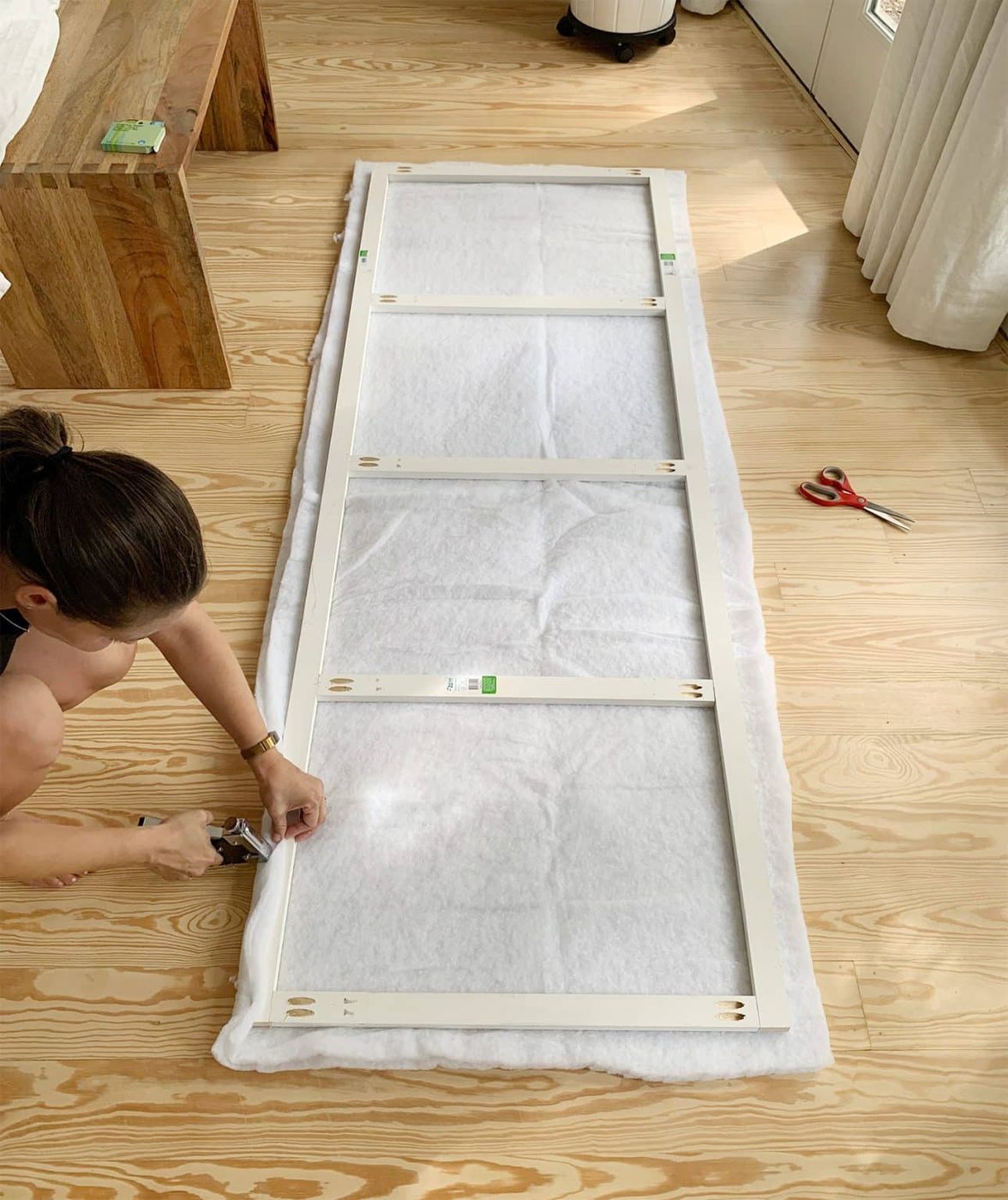 Sherry stapling two layers of batting to second larger wood frame for Hands-on headboard