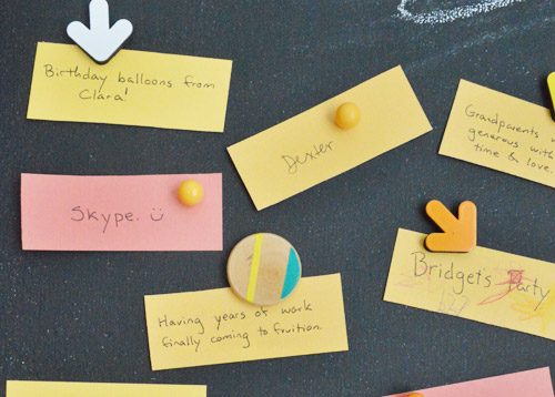 Magnetic chalkboard with colorful Thanksgiving gratitude notes held up with lively magnets
