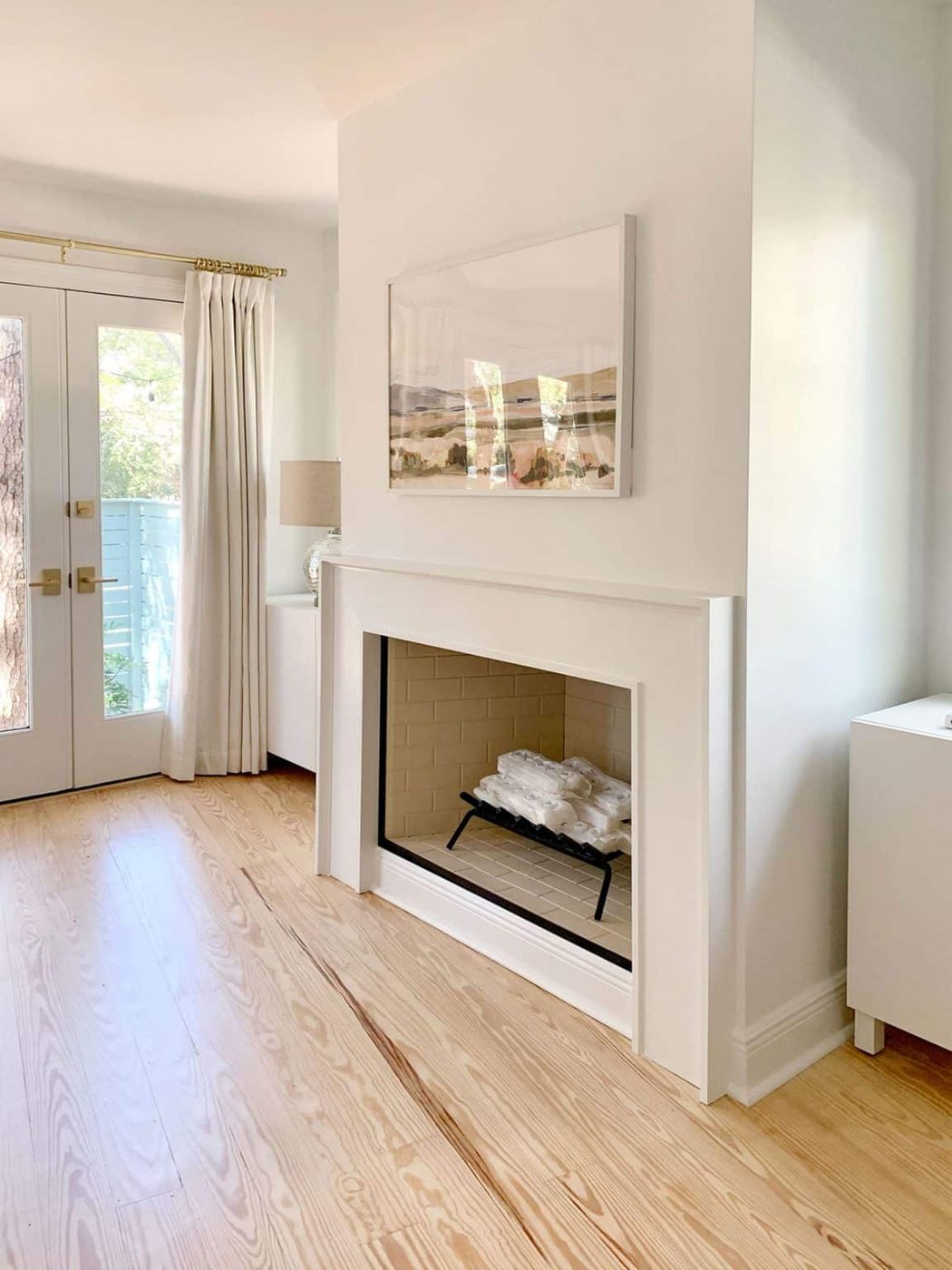 White modern fireplace with Ikea Besta storage cabinets sitting on either side