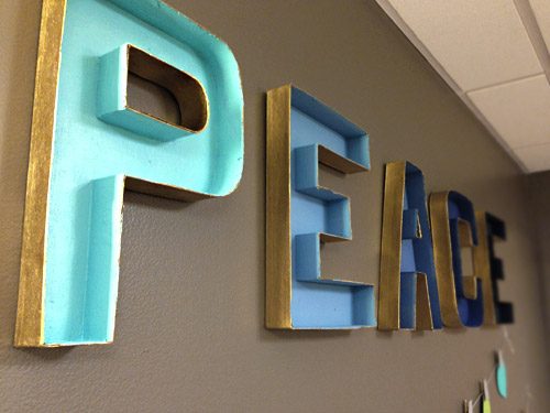 Wrapped up cardboard craft letters painted in gradient for holiday decorations in Childrens Hospital of Richmond