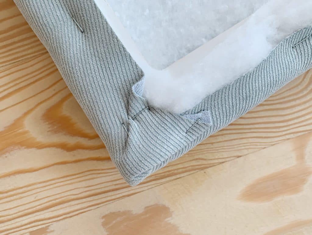 Detail of fabric stapled around corner of Hands-on headboard for boys bedroom