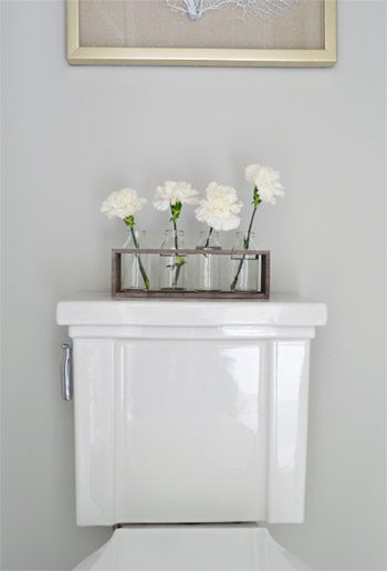 Detail Of Faux Flowers On Top Of Toilet Tank In Modern Show House Bathroom