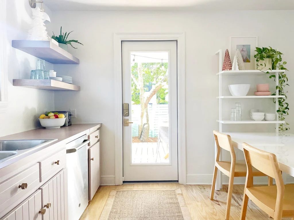 white kitchen with door out to patio