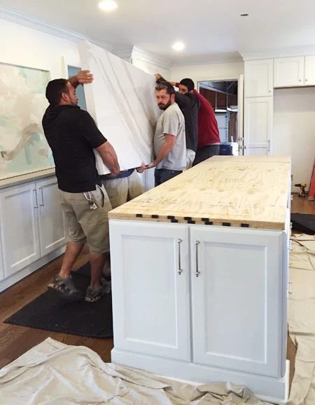 white-kitchen-remodel-carrying-in-double-thick-island