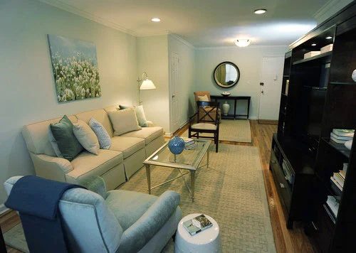 A Pale Blue Living Room Makeover Alongside A Tan Rug