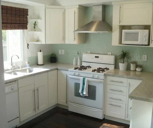 A White Kitchen Alongside Green Glass Mosaic Backsplash Tile