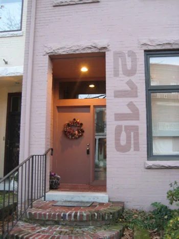 A Large Painted House Number On A Brick House: a house log
