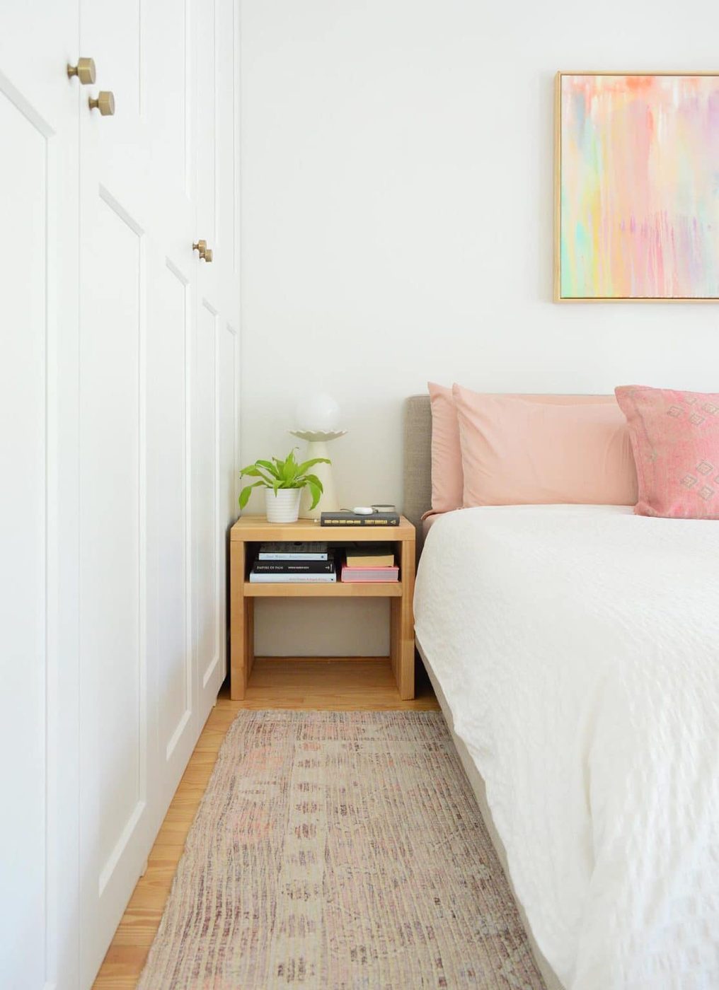 Bedroom With White Ikea Closets Next To White King Bed With Hands-on Nightstand
