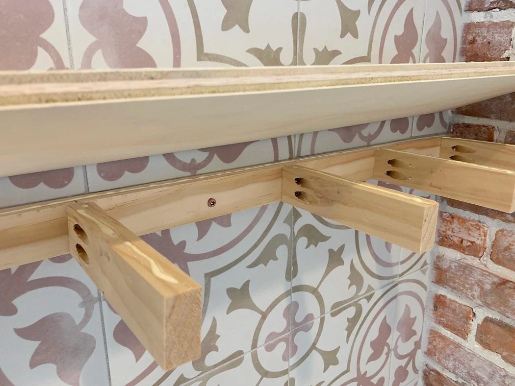 Plywood Top Being Lowered Onto Wooden Support Bracket For Hands-on Floating Shelves