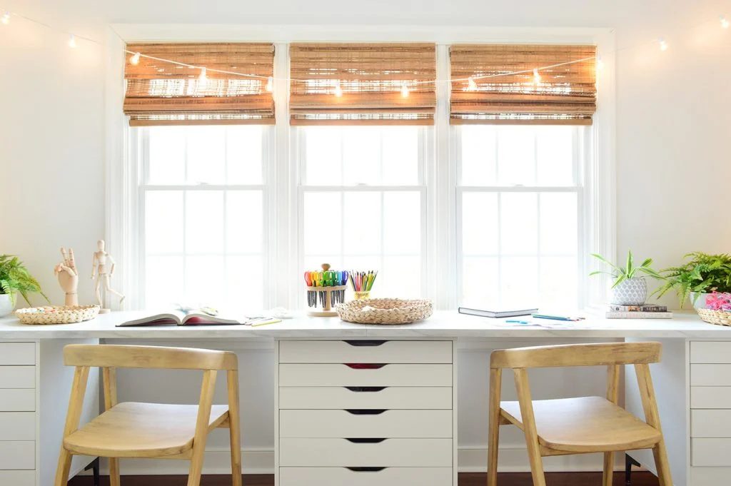 Straight View Of Kids Oversized Art Desk With Faux Marble Desktop In Front Of Window With String Lights