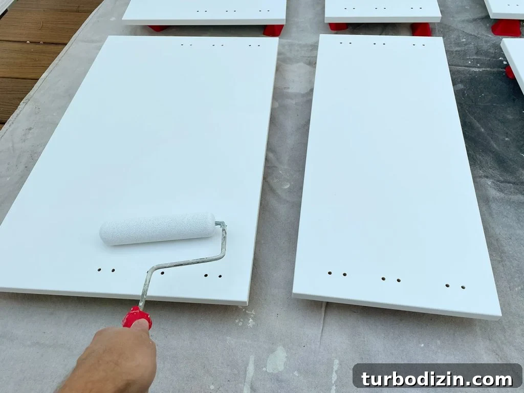 How to Paint IKEA Kitchen Cabinets Like a Pro 10 Applying Primer To Cabinet Door With Small Foam Roller