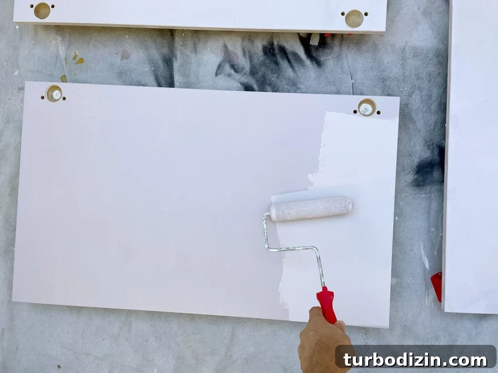 How to Paint IKEA Kitchen Cabinets Like a Pro 11 Applying Pink Paint To Ikea Kitchen Cabinet Doors With Small Foam Roller