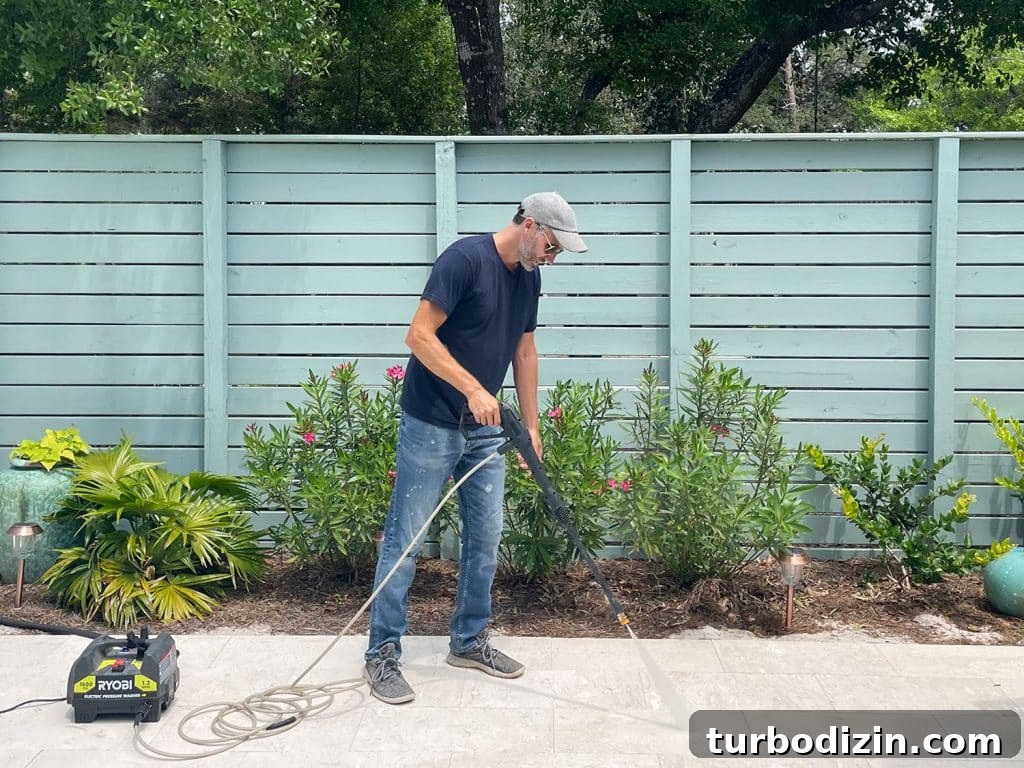 John pressure washing pool deck patio with Ryobi electric power washer