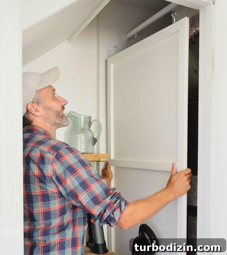 John Lifting HVAC Cover Panel Off Of Hanging Rod