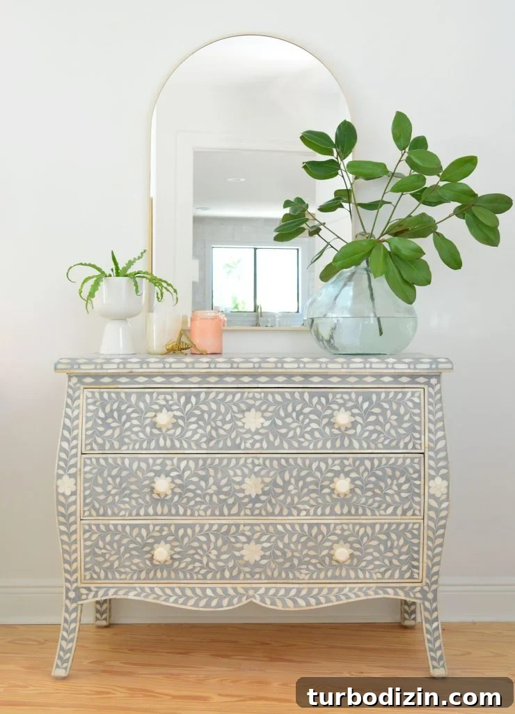 Blue and white inlay dresser with arch brass mirror and large plant vase