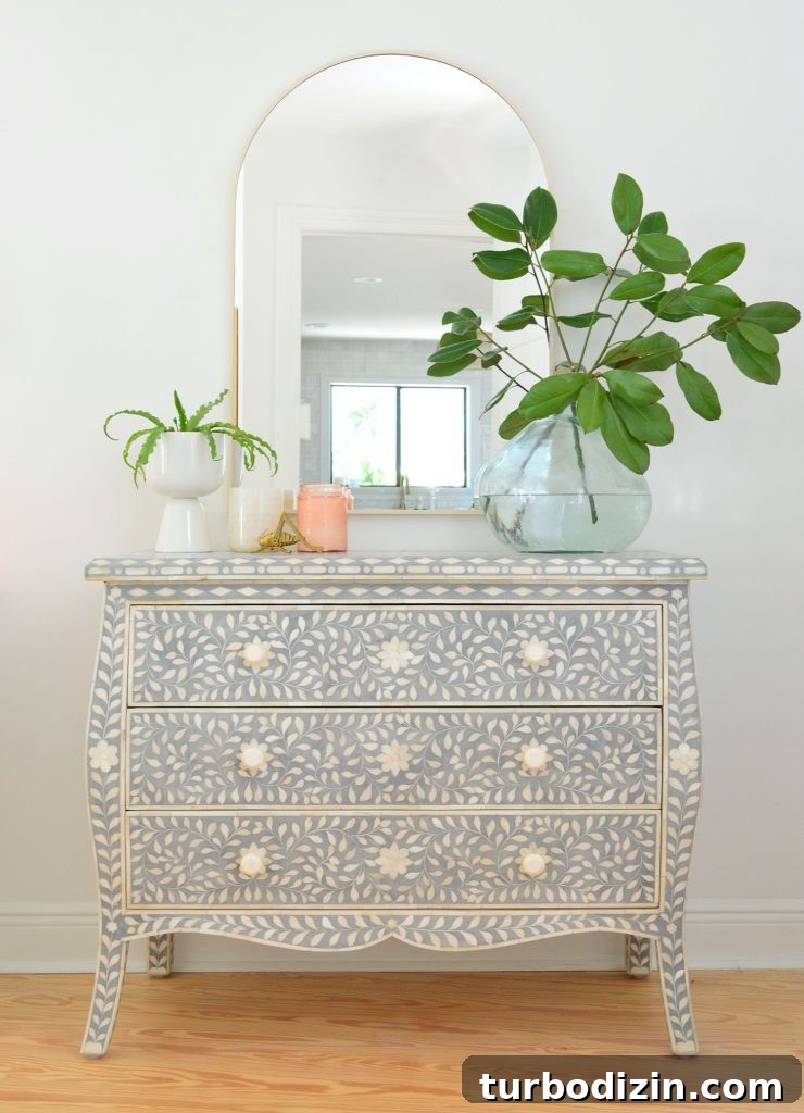 Blue and white inlay dresser with arch brass mirror and large plant vase