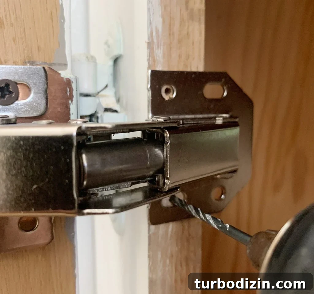 Drilling pilot hole through hidden cabinet hinge into cabinet frame