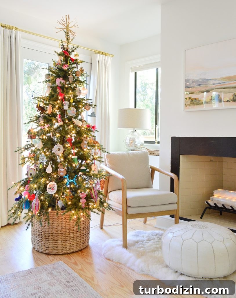 Slim Faux Christmas Tree In Woven Basket Next To Modern Chair And Fireplace